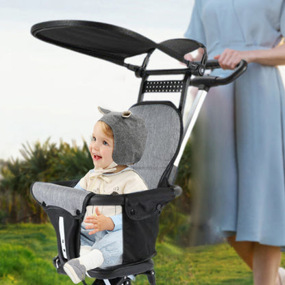 Mom Walking A Baby In A Black Foldable Baby Stroller In A Park