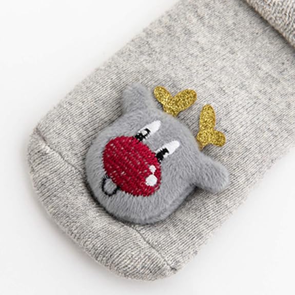 Close Up Photo Of Gray Christmas Baby Socks With Reindeer Design In A White Background