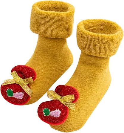 A Pair Of Yellow Christmas Baby Socks With Christmas Bag Design In A White Background