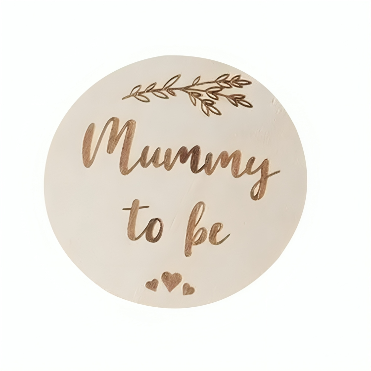 Round badge with Mummy to be text in cursive and leaf decoration on a white background.