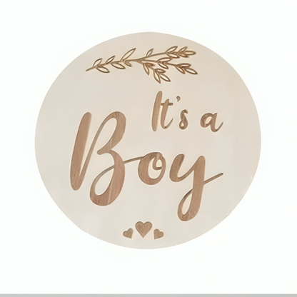 Round plaque with It's a Boy text and decorative leaves in a white background