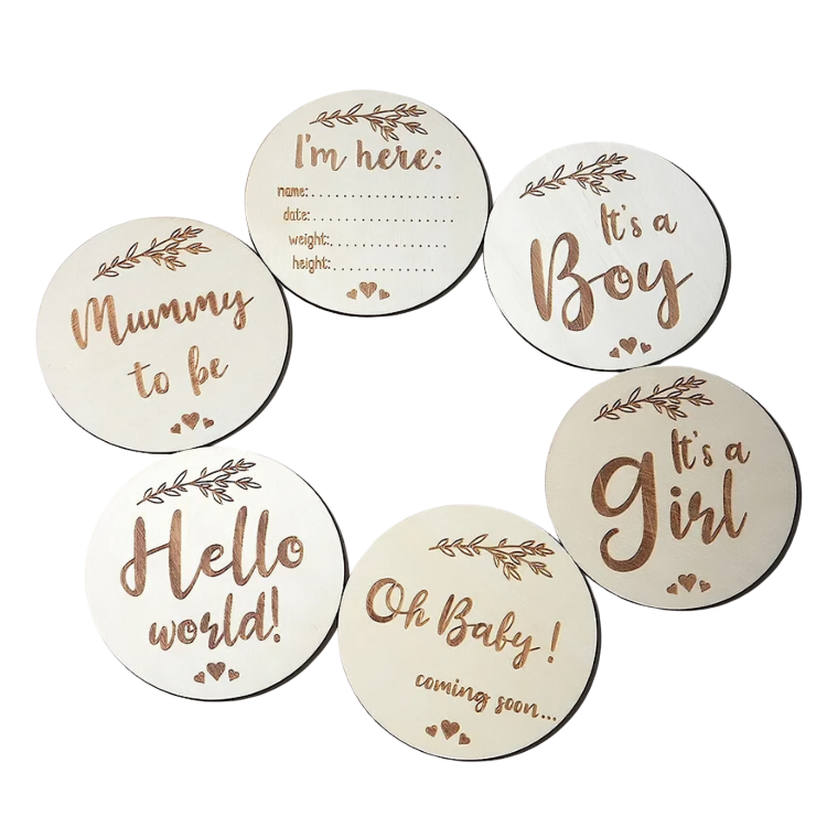 Six wooden discs with baby milestone phrases like Mummy to be and Hello world.