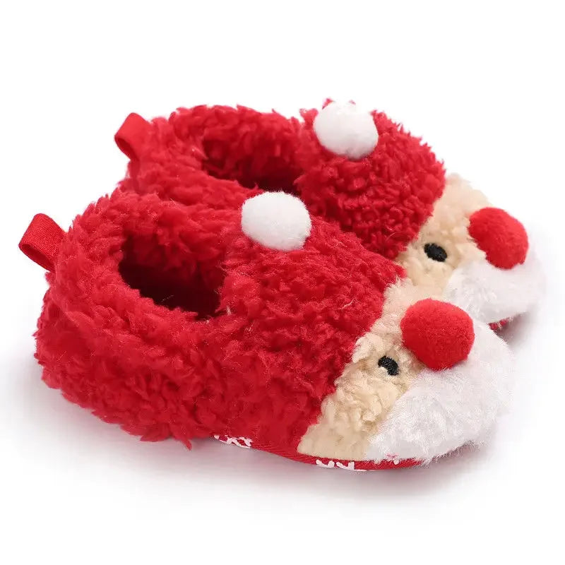 A pair of red baby winter shoes featuring a cheerful Santa Claus face on the front In A White Background