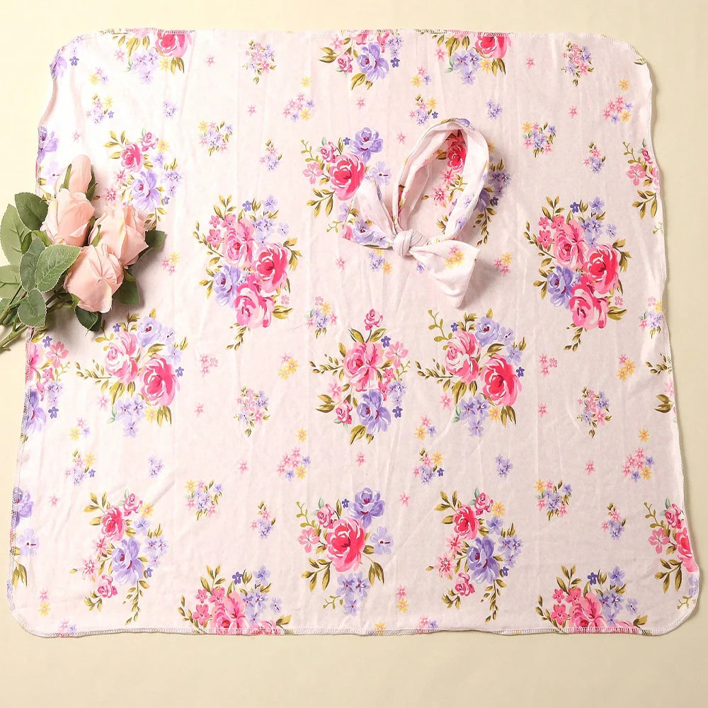 Floral headband and matching blanket with pink roses and blue flowers on a white background.