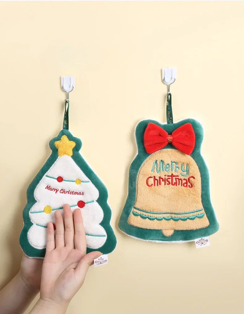 Two Christmas Themed Hanging Towel Attached To A Nude Color Wall With Person Wiping His Hand On One Of The Towel