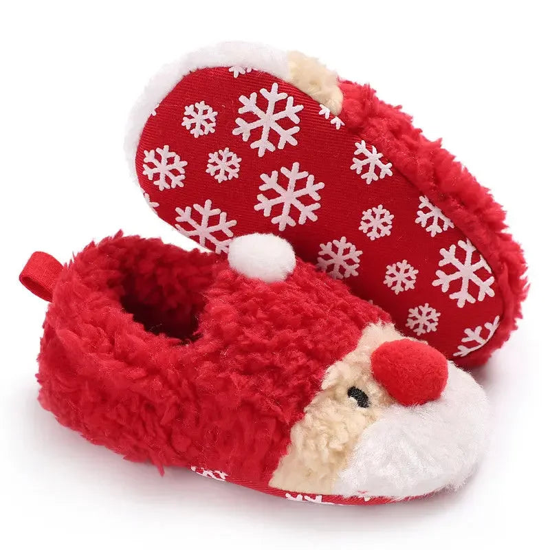 A pair of red baby winter shoes featuring a cheerful Santa Claus face on the front and snowflake printed outsole In A White Background