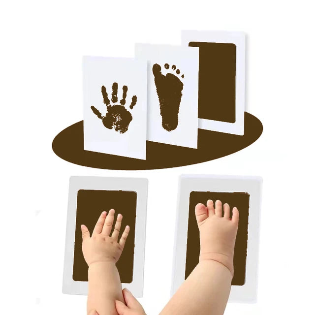 Child's hand and foot with brown paint next to paper prints of them.