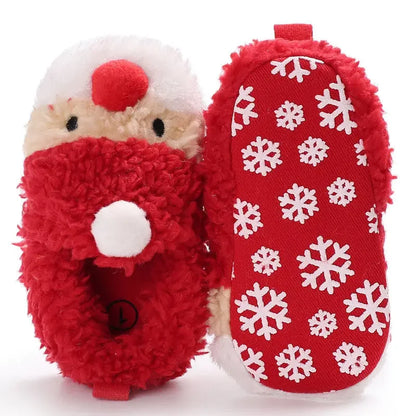 A pair of red baby winter shoes featuring a cheerful Santa Claus face on the front and snowflake printed outsole In A White Background