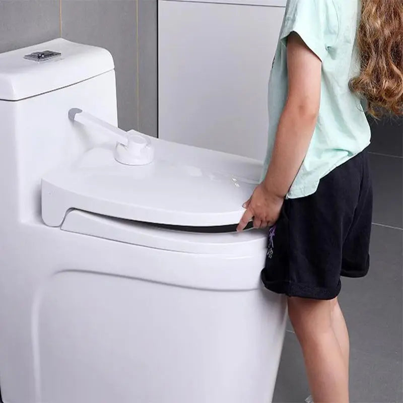 A Child Trying to open a toilet seat with a toilet lock 