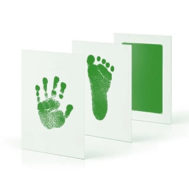 Three folded cards with green handprint, footprint, and solid color.