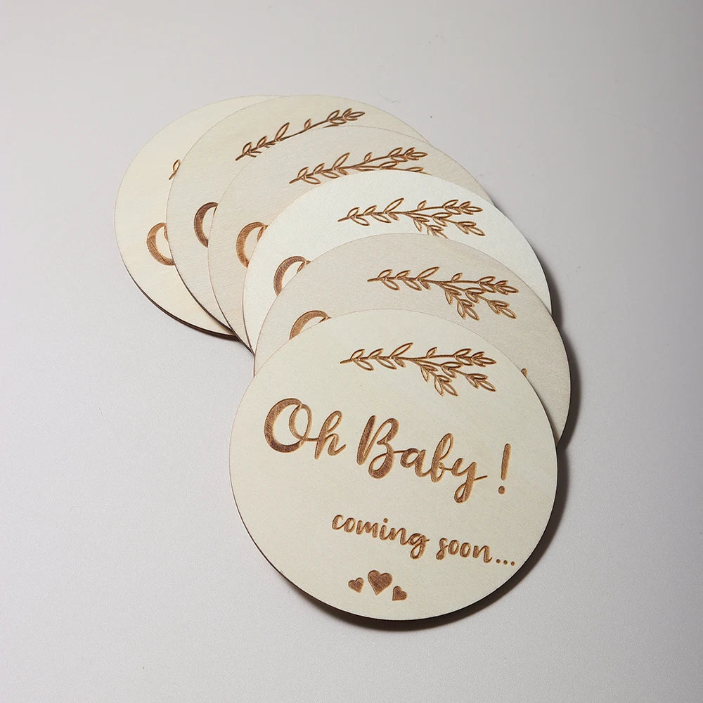 Stack of wooden coasters with Oh Baby! coming soon... etched on top, with leaf designs.