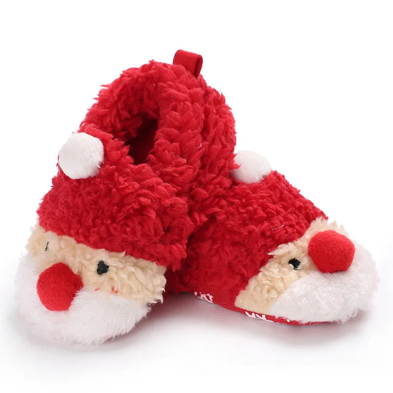 A pair of red baby winter shoes featuring a cheerful Santa Claus face on the front In A White Background