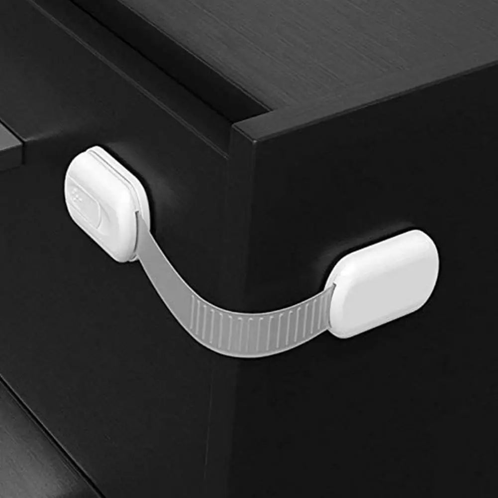 Child safety lock on a cabinet drawer in a monochrome setting.