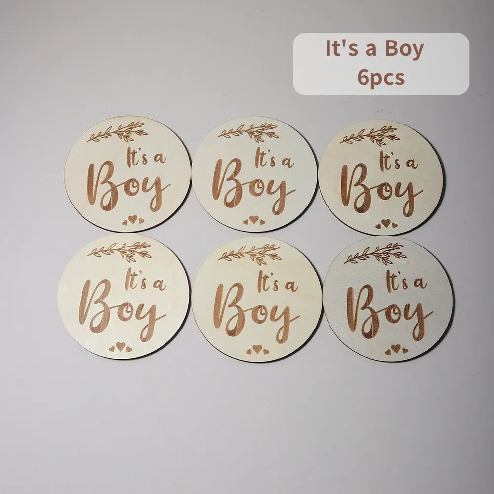 Six wooden discs with It's a Boy text, floral accents, and packaging label.