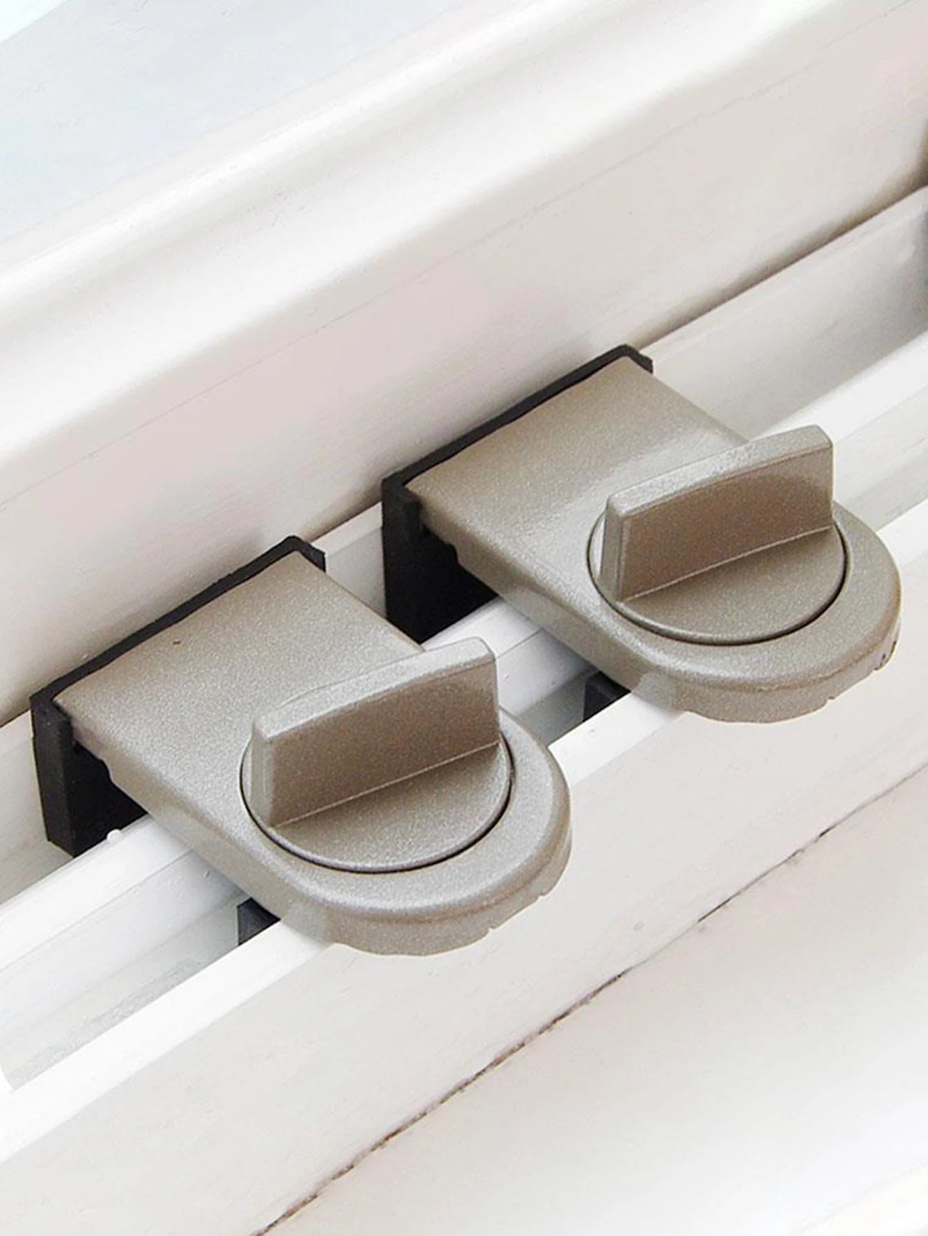 Two Brown Window sliding lock installed on a sliding window